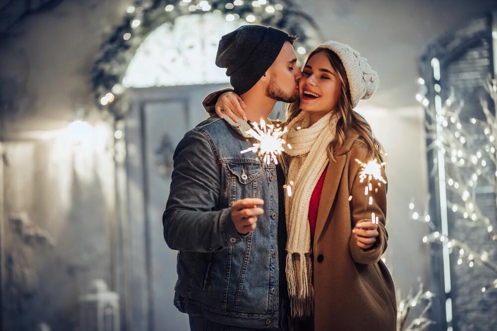 Zaljubljeni par sa prskalicama uživa u novogodišnjoj euforiji
