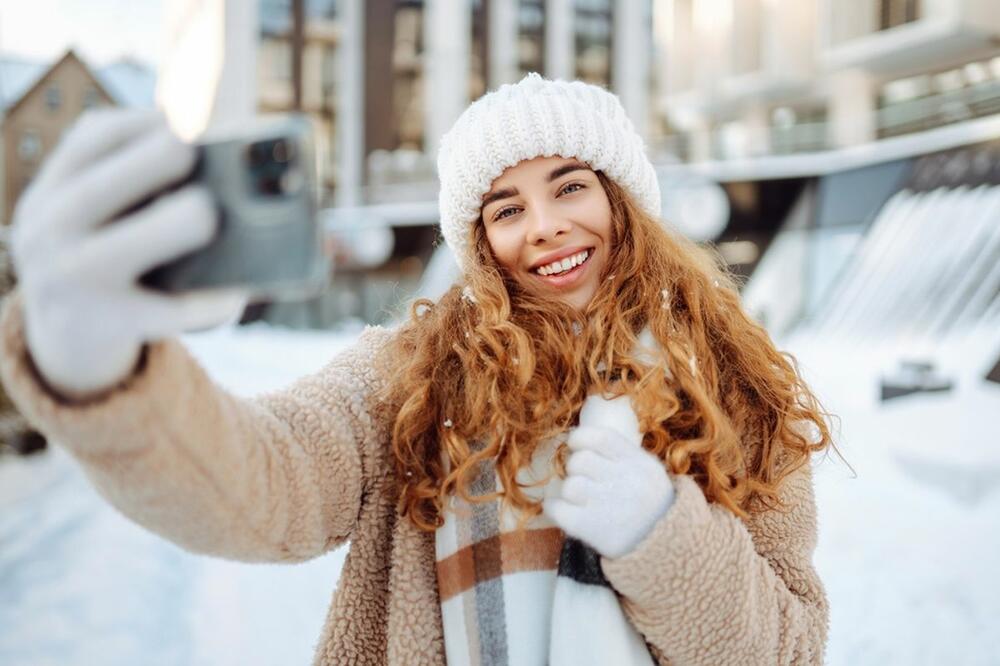 Devojka snima selfi na snegu