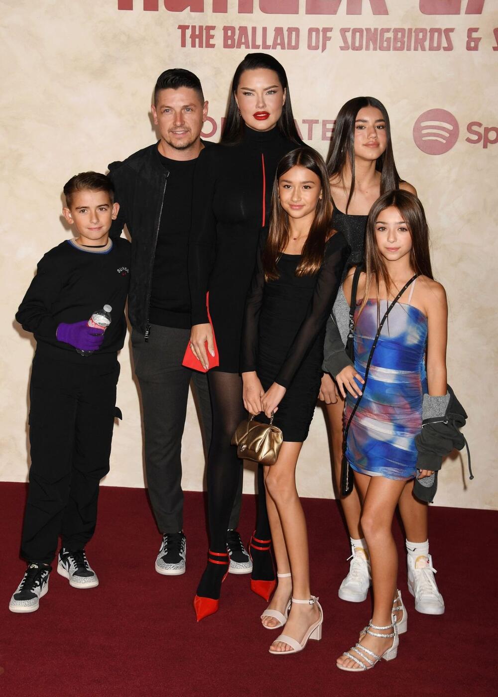Adrijana Lima je sa ćerkama i verenikom gledala premijeru novog filma "Igre gladi" u crnoj mini-haljini modne kuće Ferragamo sa crvenim detaljima