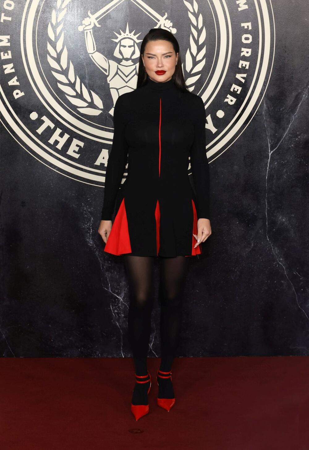 Adrijana Lima je sa ćerkama i verenikom gledala premijeru novog filma "Igre gladi" u crnoj mini-haljini modne kuće Ferragamo sa crvenim detaljima