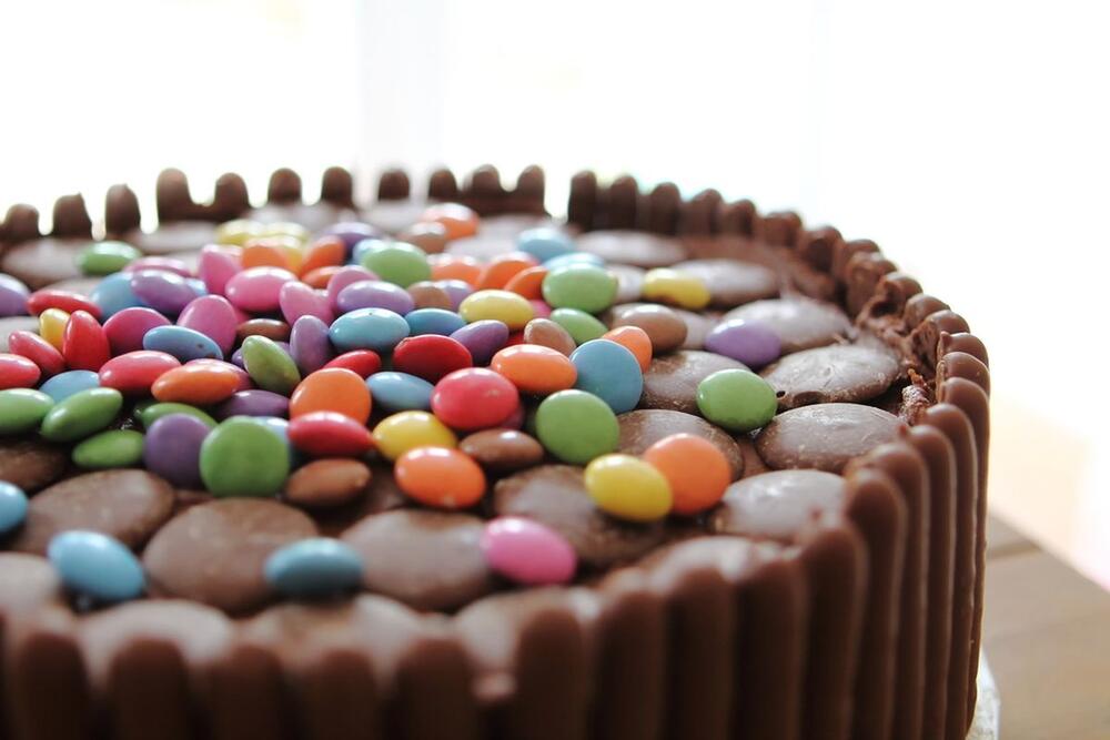 Čokoladna torta sa šarenim bombonama nazvana dugme