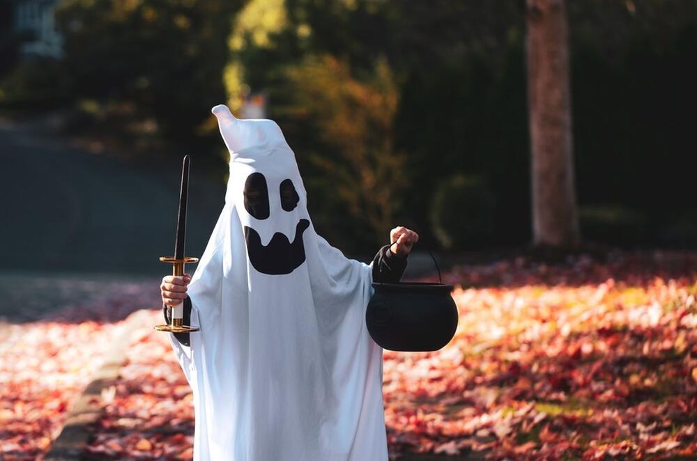 Dete maskirano u duha na Noć veštica, spremno za trick-or-treat