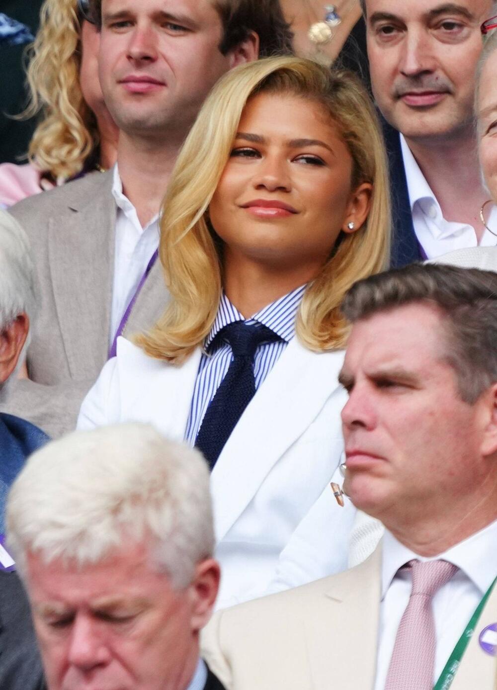 Zendeja u belom sakou i prugastoj košulji s kravatom 2024. godine