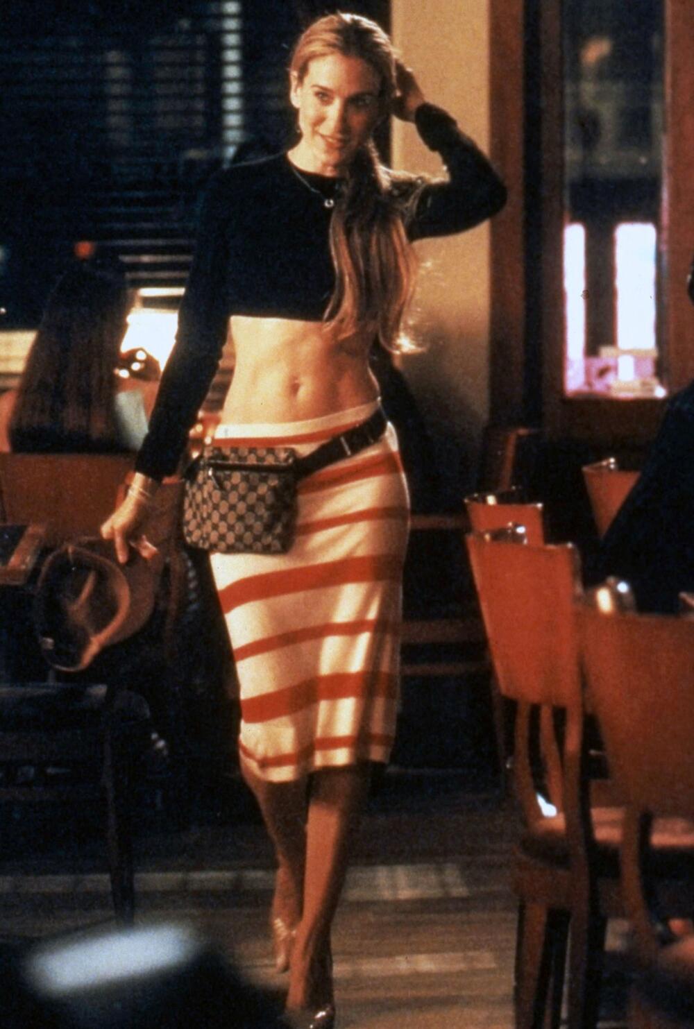 <b> Krop top i suknja na pruge </b>
Mnogo pre nego što je Emili Ratajkovski počela da "iskače iz frižidera" golog stomaka i kad ga ne očekujete, ovo je bio najveći trend 90-ih, pa se podrazumeva da ga je "it" devojka Keri Bredšo obožavala. Ona je imala mnogo krop topova, a u četvrtoj sezoni smo je videli u crnom Prada modelu dugih rukava u kombinaciji s belo-crvenom Prada suknjom na pruge. Dodajte tome i Gucci torbu koja je tada bila na svakom koraku i imate prepoznatljivi Y2K stil.