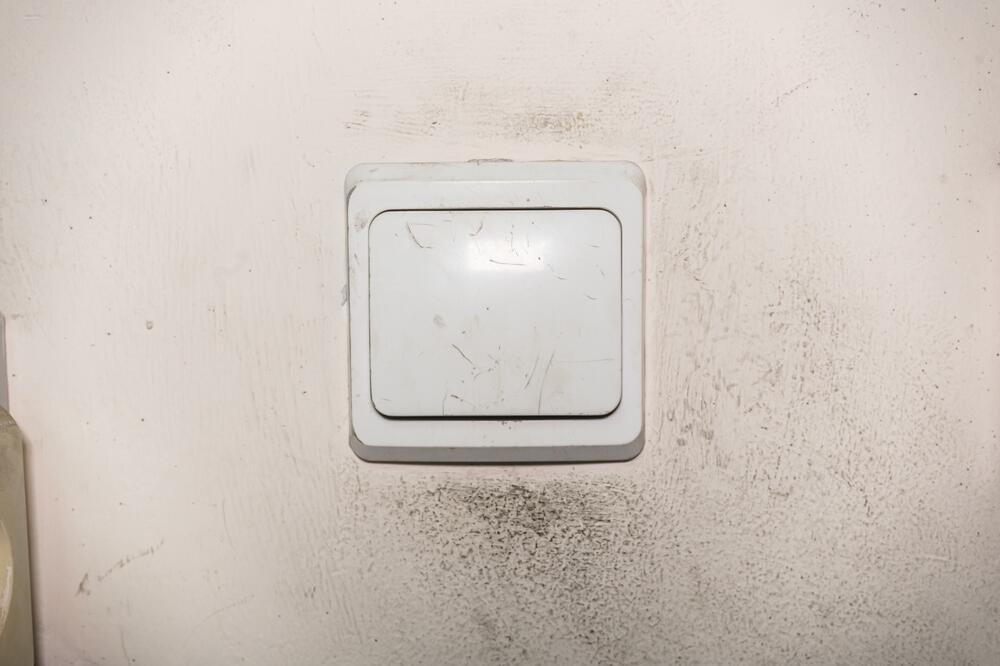 Prljav i izgreban prekidač i zid oko njega