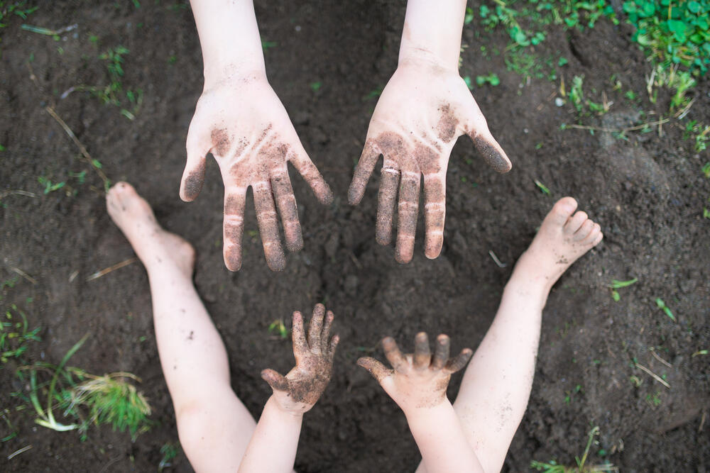 Majka i dete se igraju u prljavštini