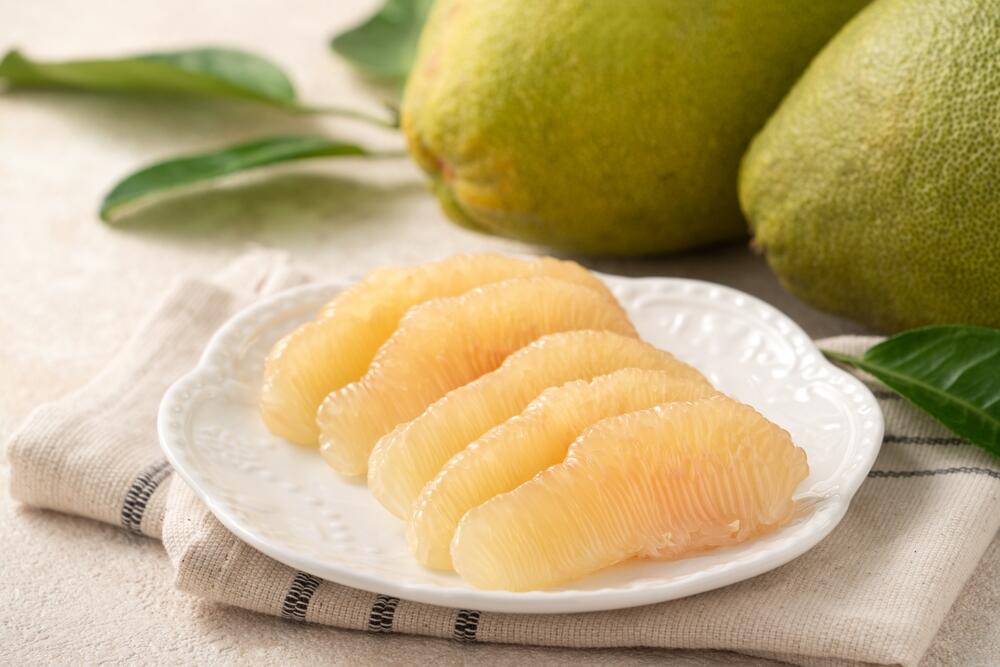 Svež pomelo na tanjiru, podeljen na kriške
